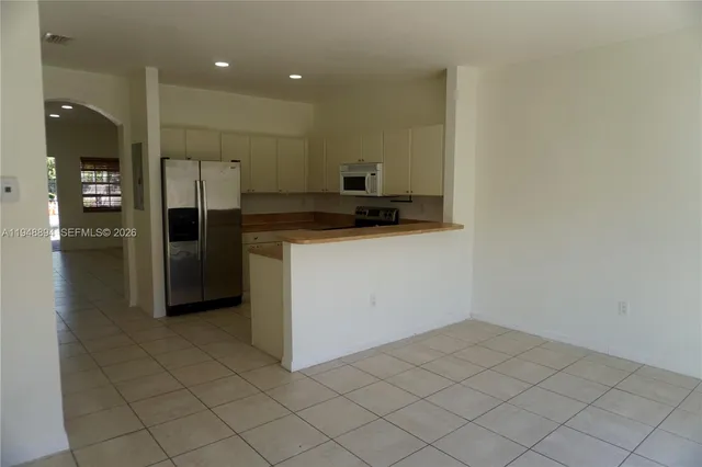 a kitchen with a sink a refrigerator and cabinets