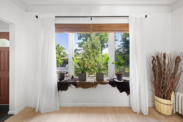 a view of a living room with a large window and flower pot