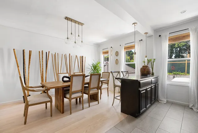 a living room with furniture a large window and a chandelier