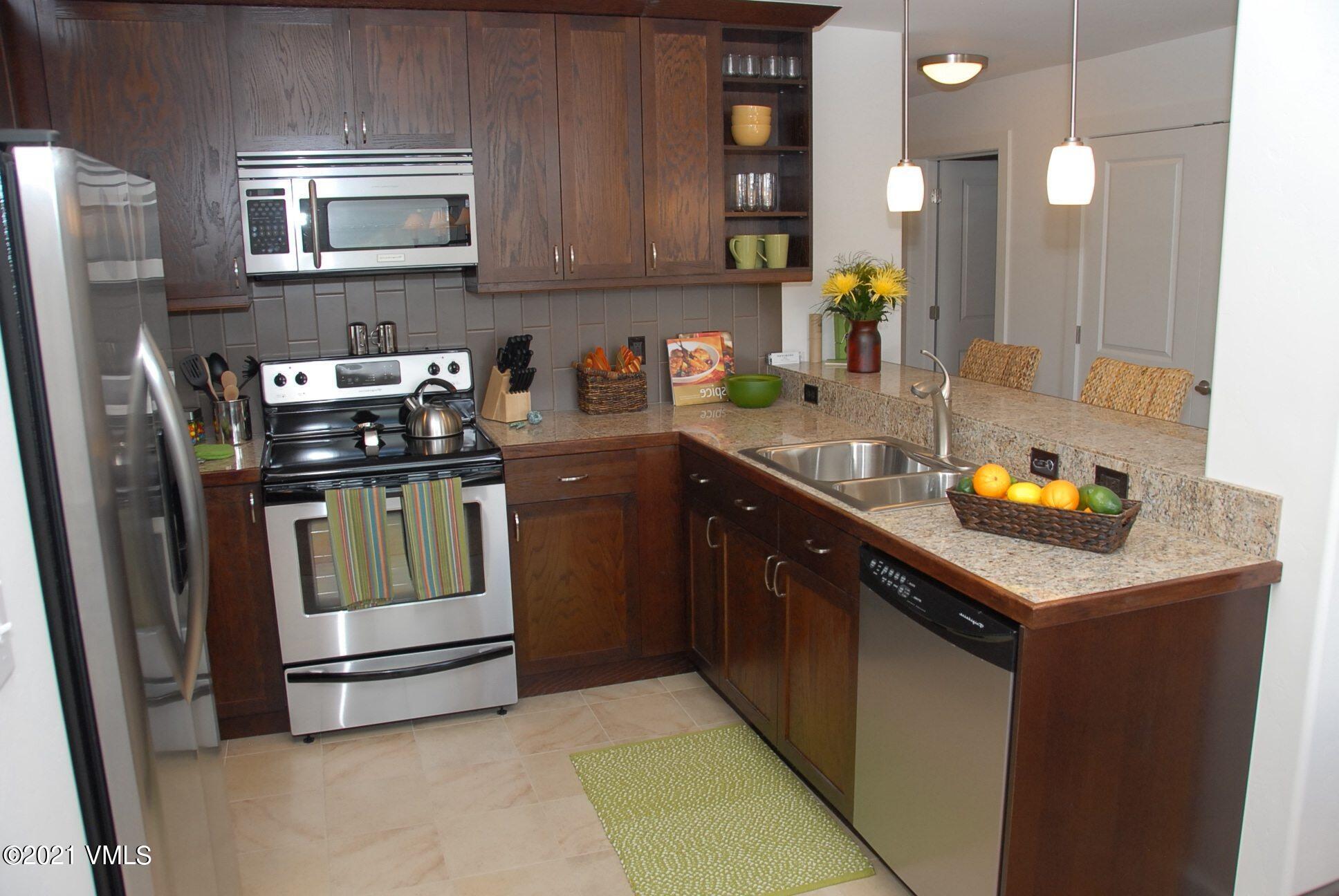 80 Freestone Road, Unit C101 Eagle, CO 81631 - Photo 8 of 14 a kitchen with stainless steel appliances granite countertop a sink stove and refrigerator