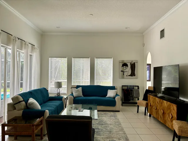 a living room with lots of furniture and a view of kitchen