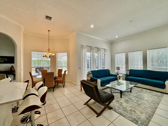 a living room with furniture and a air conditioner vent