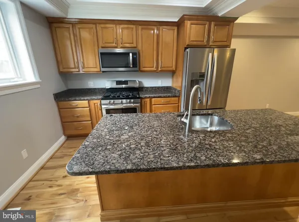 a kitchen with stainless steel appliances granite countertop a refrigerator stove top oven a sink and dishwasher