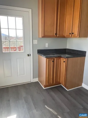 a view of a storage and utility room with wooden floor