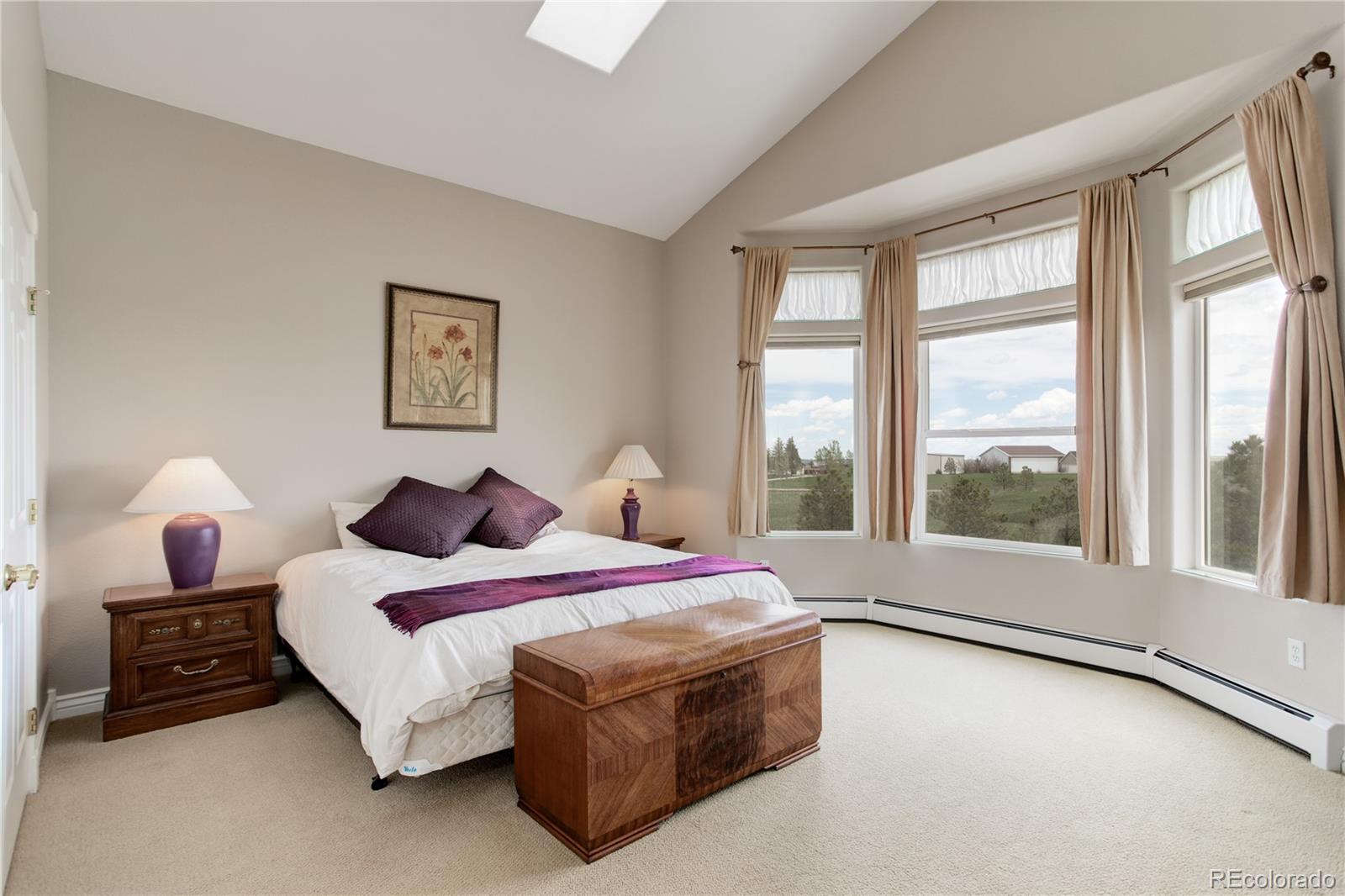 24943 Ben Kelly Road Elbert, CO 80106 - Photo 14 of 39 a spacious bedroom with a bed a large window with outer view and couch