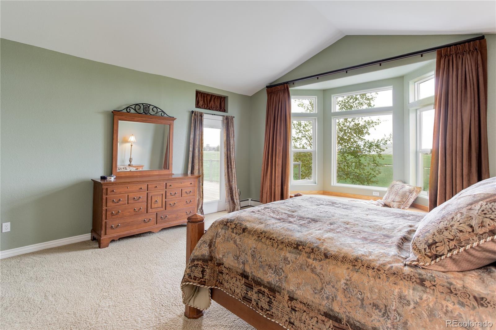 24943 Ben Kelly Road Elbert, CO 80106 - Photo 17 of 39 a bedroom with a bed and a dresser next to a window