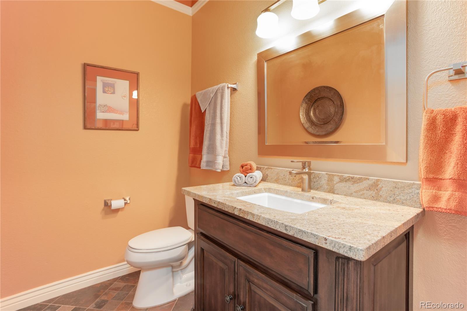 24943 Ben Kelly Road Elbert, CO 80106 - Photo 22 of 39 a bathroom with a granite countertop toilet sink and mirror