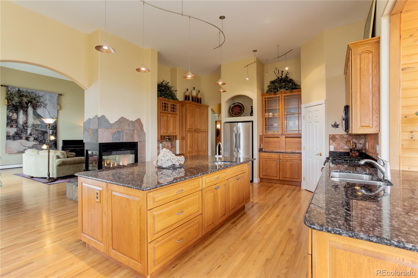24943 Ben Kelly Road Elbert, CO 80106 - Photo 24 of 39 a large kitchen with kitchen island a large counter top space a sink stainless steel appliances and cabinets