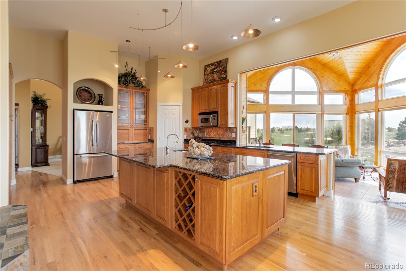 24943 Ben Kelly Road Elbert, CO 80106 - Photo 25 of 39 a kitchen with stainless steel appliances granite countertop a refrigerator a stove and a wooden floors
