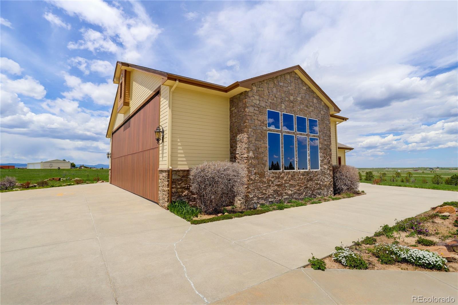 24943 Ben Kelly Road Elbert, CO 80106 - Photo 4 of 39 a front view of a house with a yard and garage