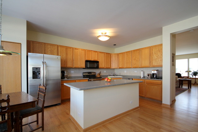 1283 Georgetown Way Vernon Hills, IL 60061 - Photo 11 of 25 a kitchen with stainless steel appliances a stove refrigerator sink and cabinets