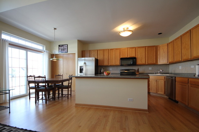 1283 Georgetown Way Vernon Hills, IL 60061 - Photo 12 of 25 a kitchen with granite countertop wooden floors furniture dining table and stainless steel appliances