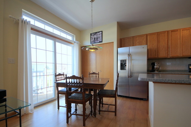 1283 Georgetown Way Vernon Hills, IL 60061 - Photo 13 of 25 a kitchen with stainless steel appliances granite countertop a refrigerator a stove a dining table and chairs with wooden floor