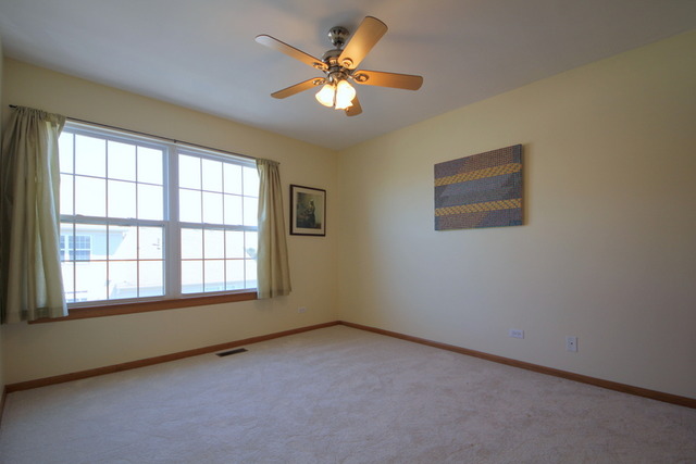1283 Georgetown Way Vernon Hills, IL 60061 - Photo 21 of 25 an empty room with a window and a ceiling fan