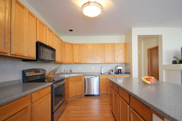 1283 Georgetown Way Vernon Hills, IL 60061 - Photo 9 of 25 a kitchen with stainless steel appliances granite countertop a sink stove and cabinets