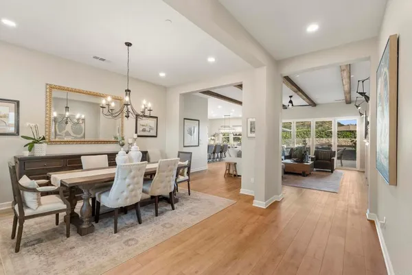 a view of a dining room and livingroom with furniture wooden floor a chandelier