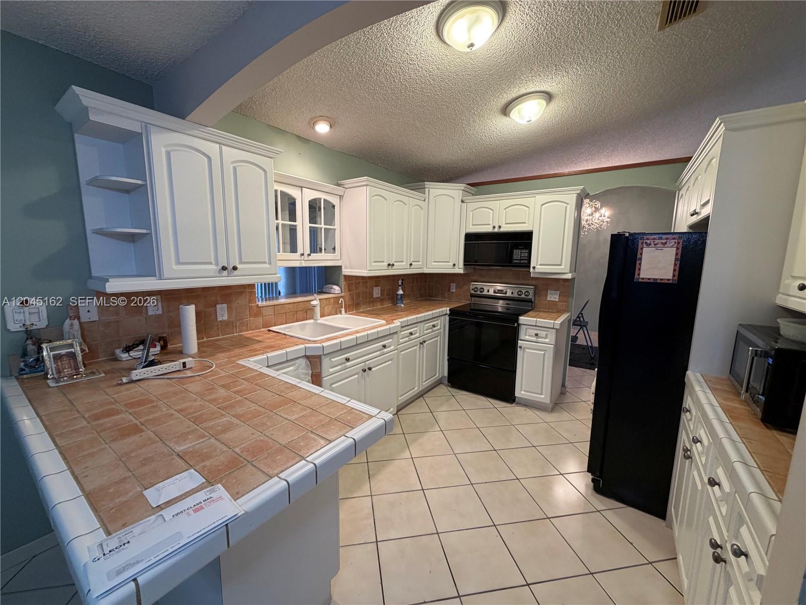3262 Southwest 139th Place Miami, FL 33175 - Photo 8 of 36 a kitchen with a sink a counter top space appliances and cabinets