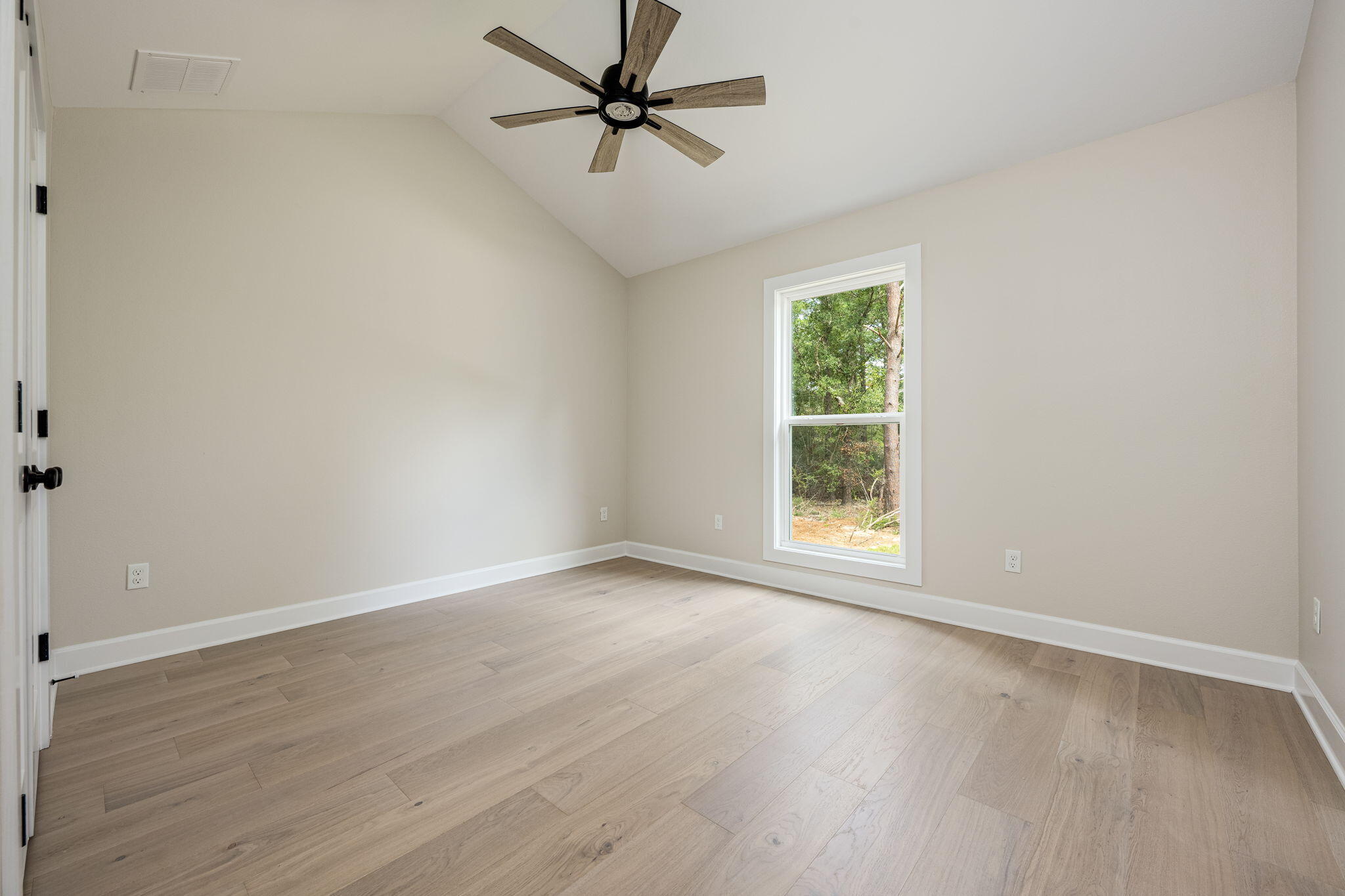 89 Spring Hill Road DeFuniak Springs, FL 32433 - Photo 32 of 73 an empty room with wooden floor fan and windows