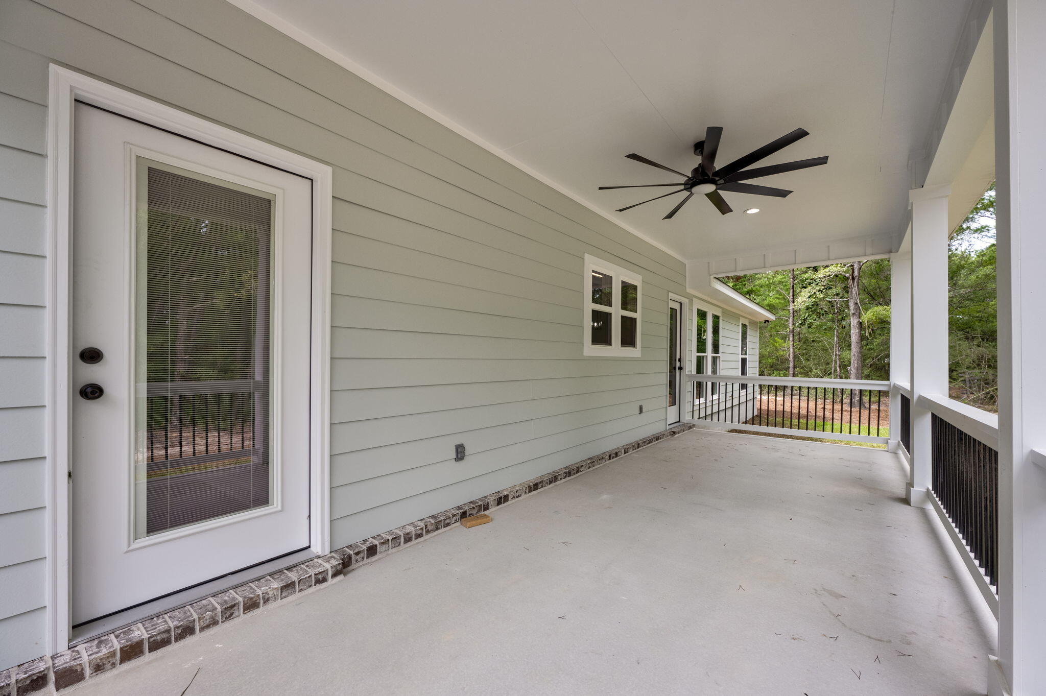 89 Spring Hill Road DeFuniak Springs, FL 32433 - Photo 62 of 73 a view of a porch with wooden floor and a ceiling fan