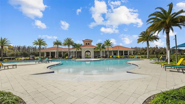 a view of swimming pool with lounge chair and dinning table under an umbrella