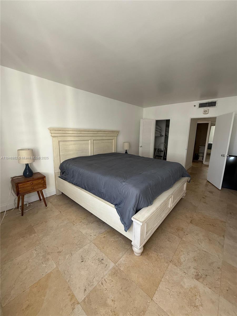 Miami Beach City Center Miami Beach, FL 33139 - Photo 11 of 41 a bedroom with a bed and a table