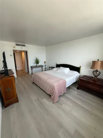 a bedroom with a bed a couch and dresser