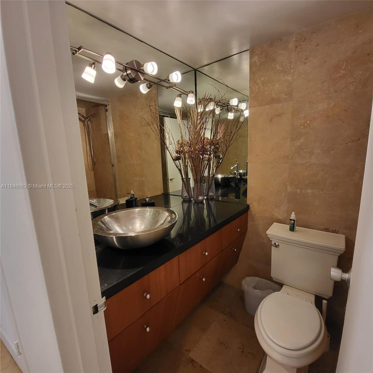 Miami Beach City Center Miami Beach, FL 33139 - Photo 18 of 41 a bathroom with a toilet a sink and mirror