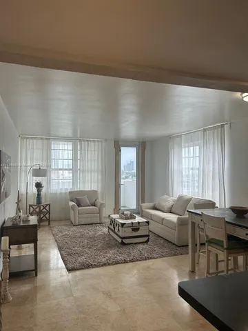 a living room with furniture wooden floor and a large window