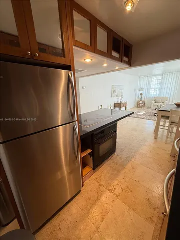 a kitchen with stainless steel appliances granite countertop a refrigerator and a stove top oven