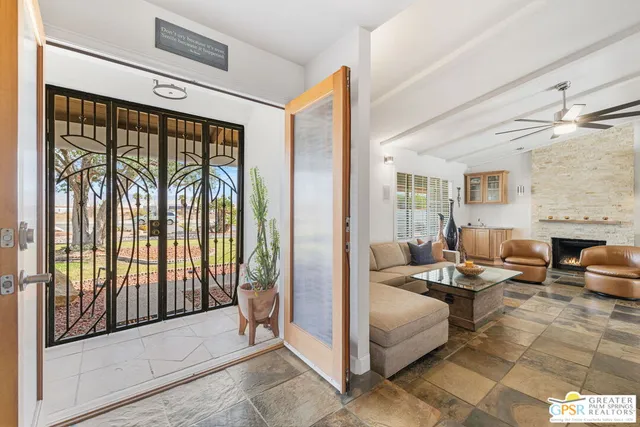 a living room with furniture and a floor to ceiling window