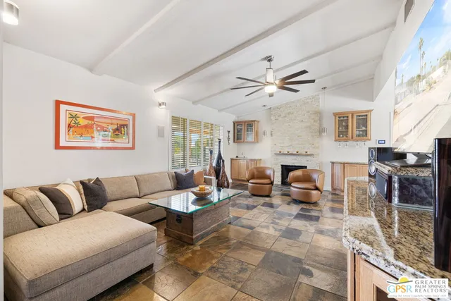 a living room with furniture a fireplace and a large window