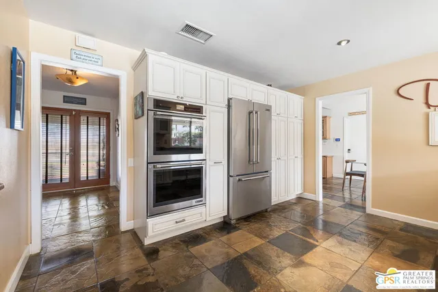 a kitchen with granite countertop a refrigerator and a stove top oven