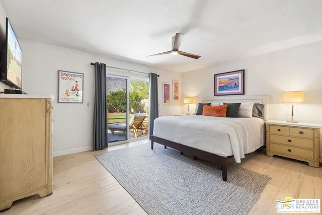 a spacious bedroom with a bed and a flat screen tv