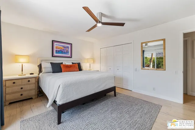 a bedroom with a bed and a painting on the wall