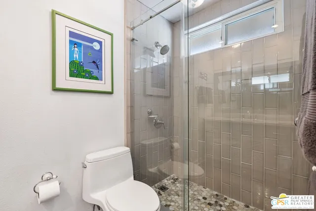 a white toilet sitting next to a bathroom shower