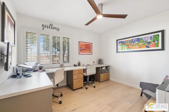 a view of a workspace with furniture and a window