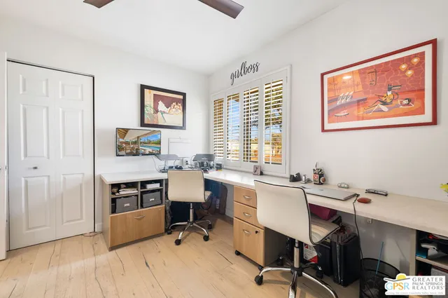 a view of a workspace with furniture and a window