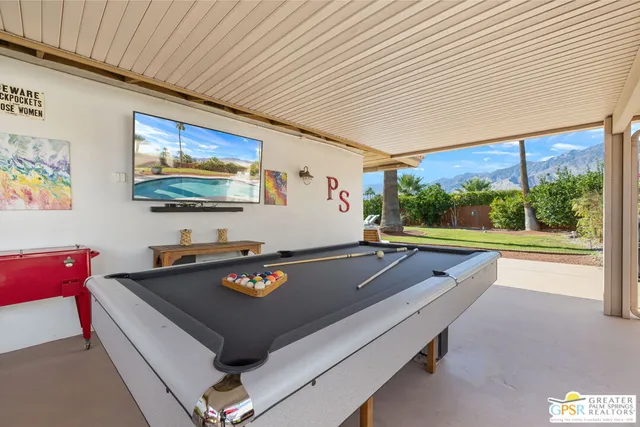a room with furniture pool table and windows