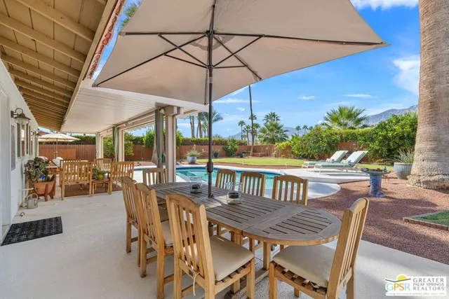a view of a patio with a table chairs and a umbrella