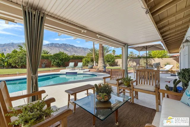a living room with large windows and a table