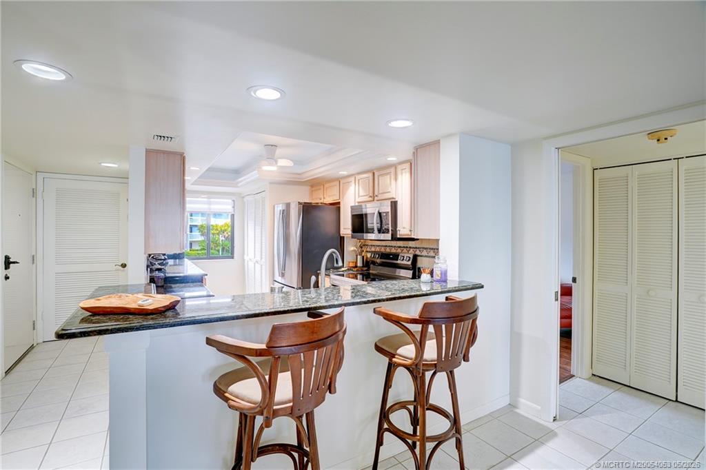 10 Northeast Plantation Road, Unit 101 Jensen Beach, FL 34957 - Photo 34 of 53 a kitchen with stainless steel appliances granite countertop counter top space cabinets and a sink