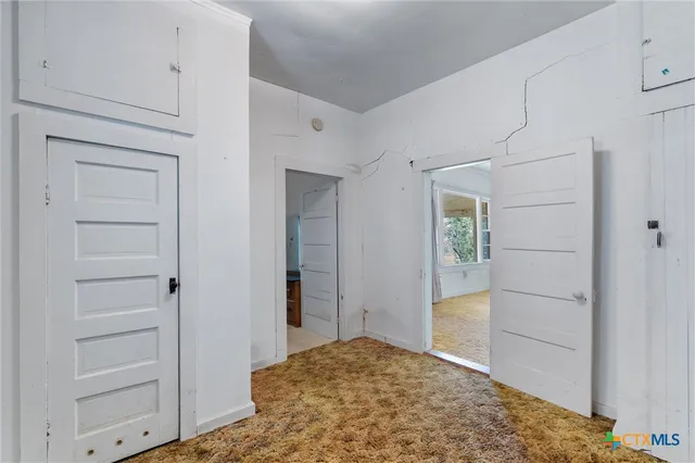 a view of an empty room with window and bathroom