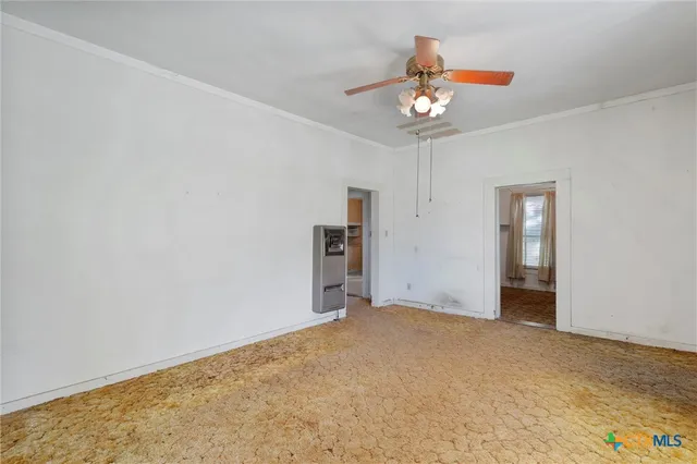 an empty room with chandelier fan and closet
