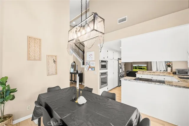 a kitchen with stainless steel appliances kitchen island granite countertop a table chairs in it and wooden floor