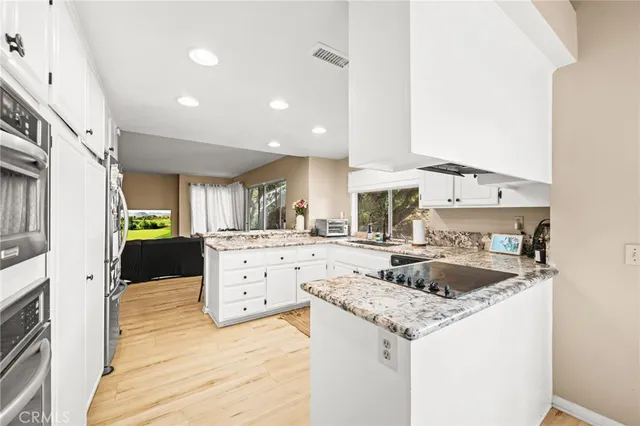 a kitchen with a stove a sink a refrigerator and cabinets