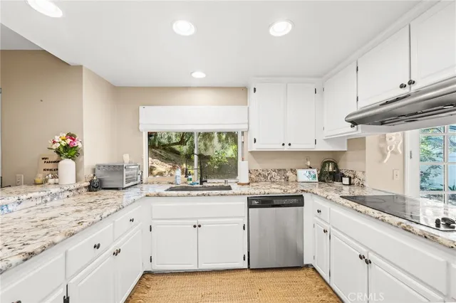 a kitchen with granite countertop white cabinets and white appliances