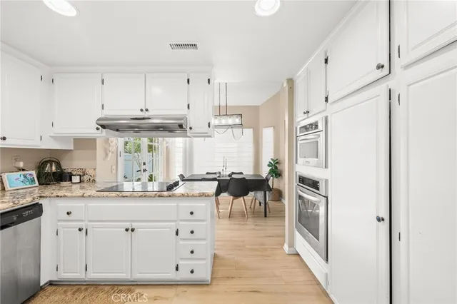 a kitchen with white cabinets and sink