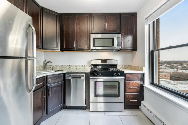 a kitchen with stainless steel appliances granite countertop a refrigerator stove and microwave