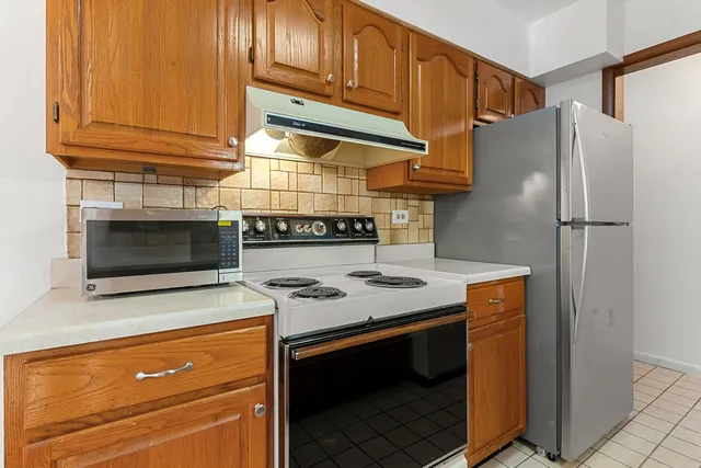 a kitchen with stainless steel appliances granite countertop a stove microwave and refrigerator