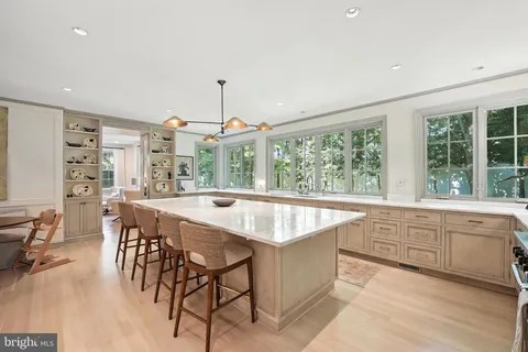 a large kitchen with kitchen island a large window in it